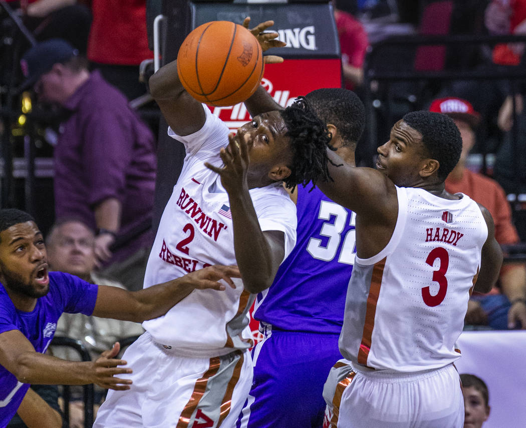 UNLV Rebels forward Donnie Tillman (2) reaches for a rebound with teammate guard Amauri Hardy ( ...