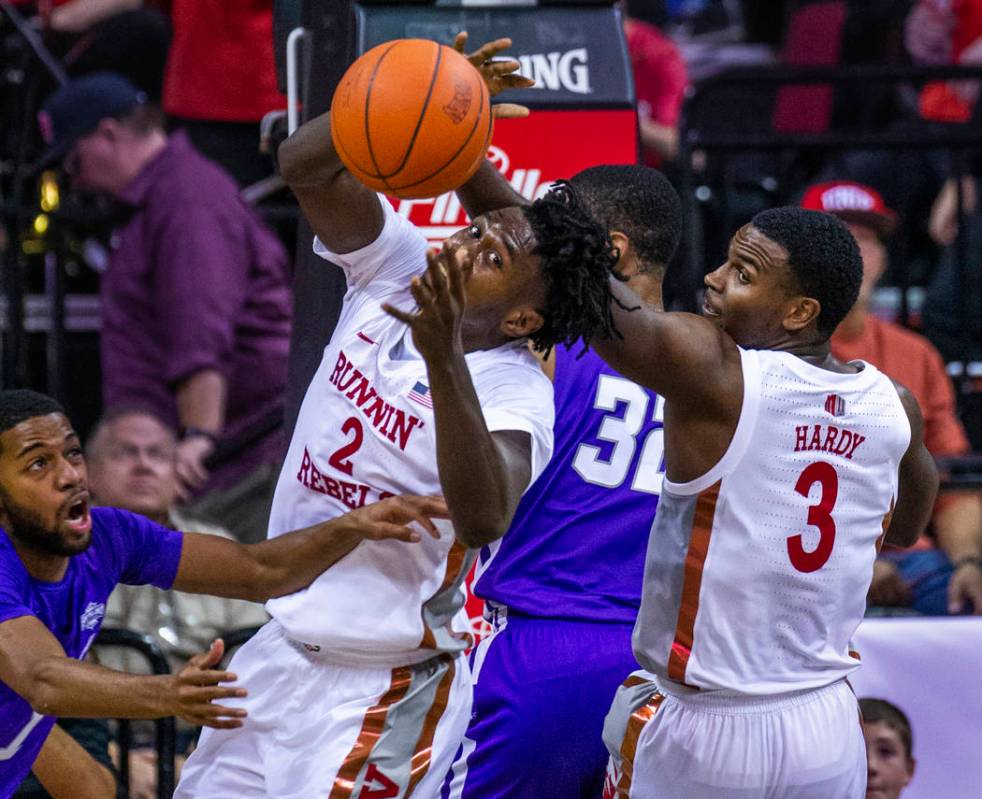 UNLV Rebels forward Donnie Tillman (2) reaches for a rebound with teammate guard Amauri Hardy ( ...