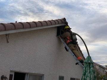 A Las Vegas Fire Department firefighter works on an attic fire in the northwest valley early Tu ...