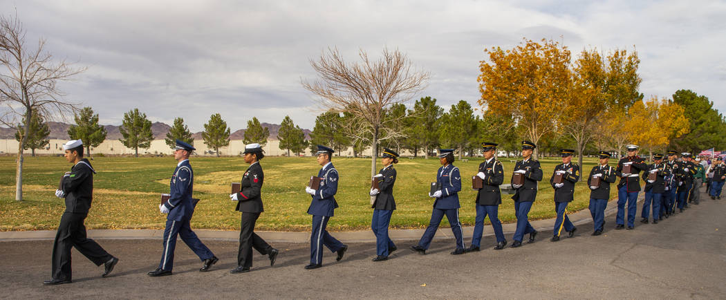 Military Honor Guard members march with urns to awaiting burial plots during the third Missing ...