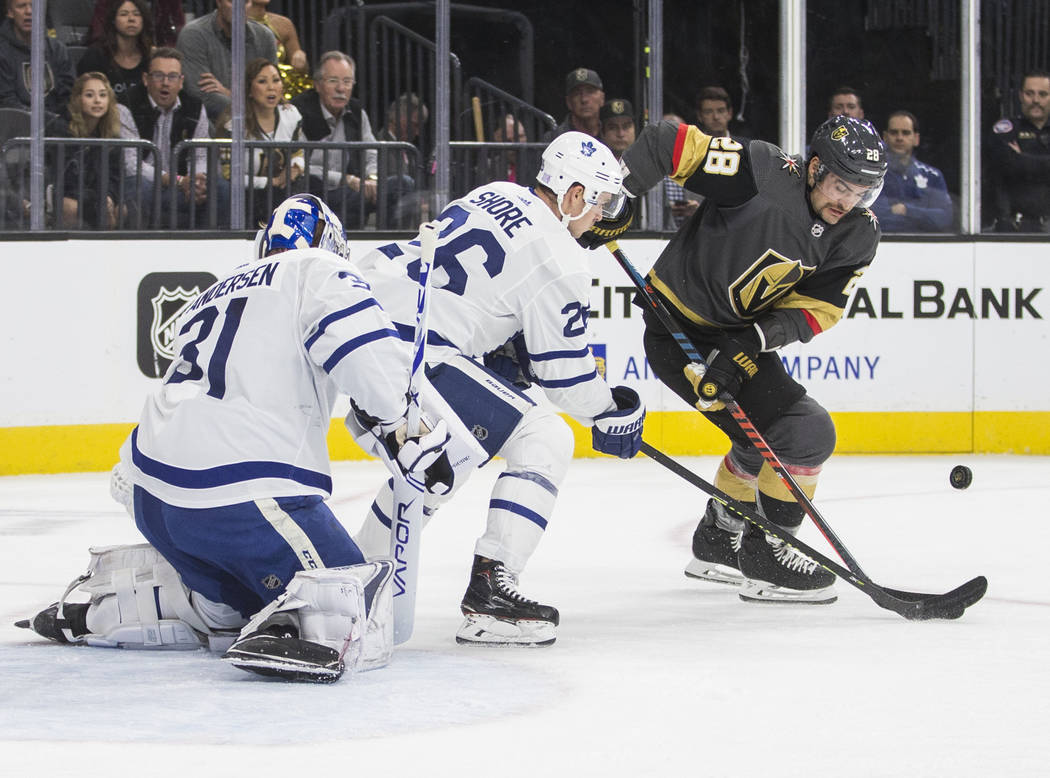 Vegas Golden Knights left wing William Carrier (28) fights for a loose puck with Toronto Maple ...