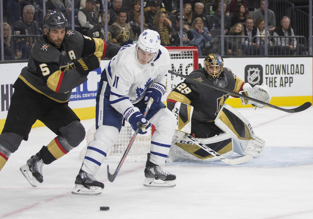 Vegas Golden Knights defenseman Deryk Engelland (5) fights for a loose puck with Toronto Maple ...