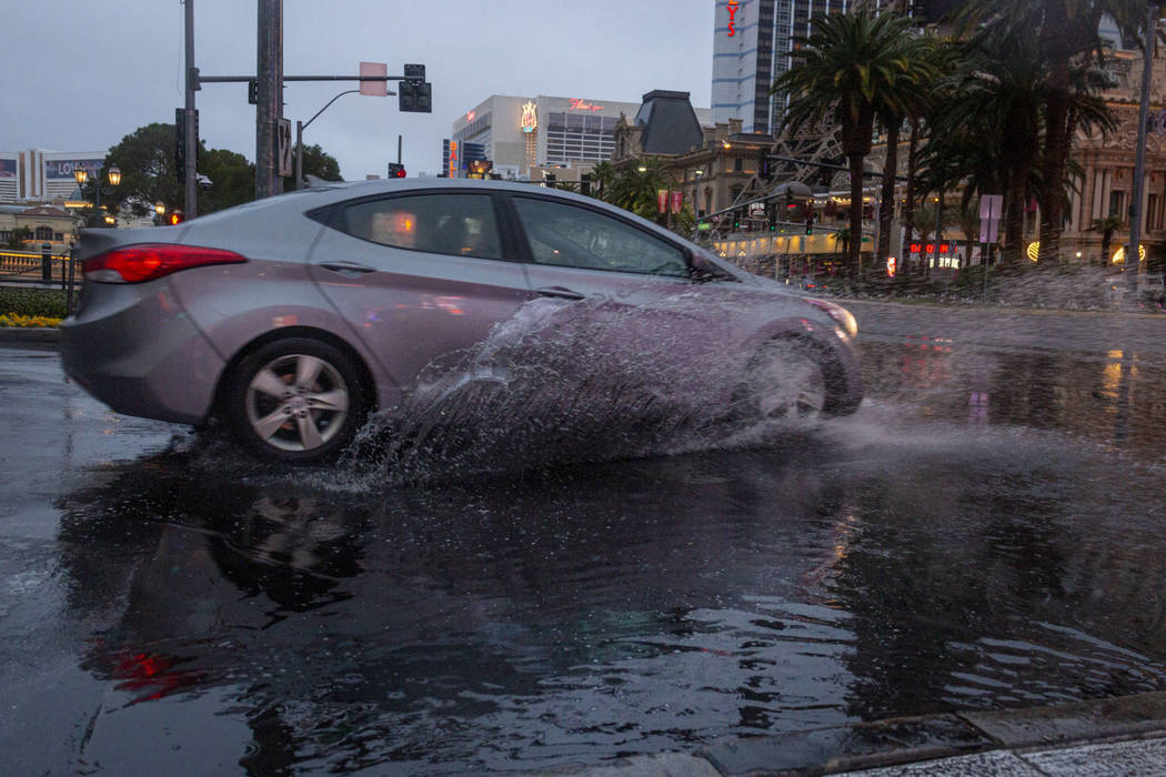 A car passes through rain water on the Strip in Las Vegas on Wednesday Nov. 20, 2019. (Elizabet ...