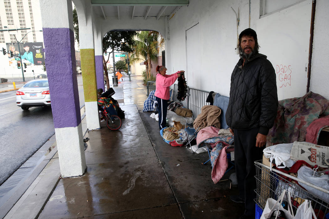 Darrell Leis, right, and Nancy Williams, 53, take shelter from the rain on Main Street near Bri ...