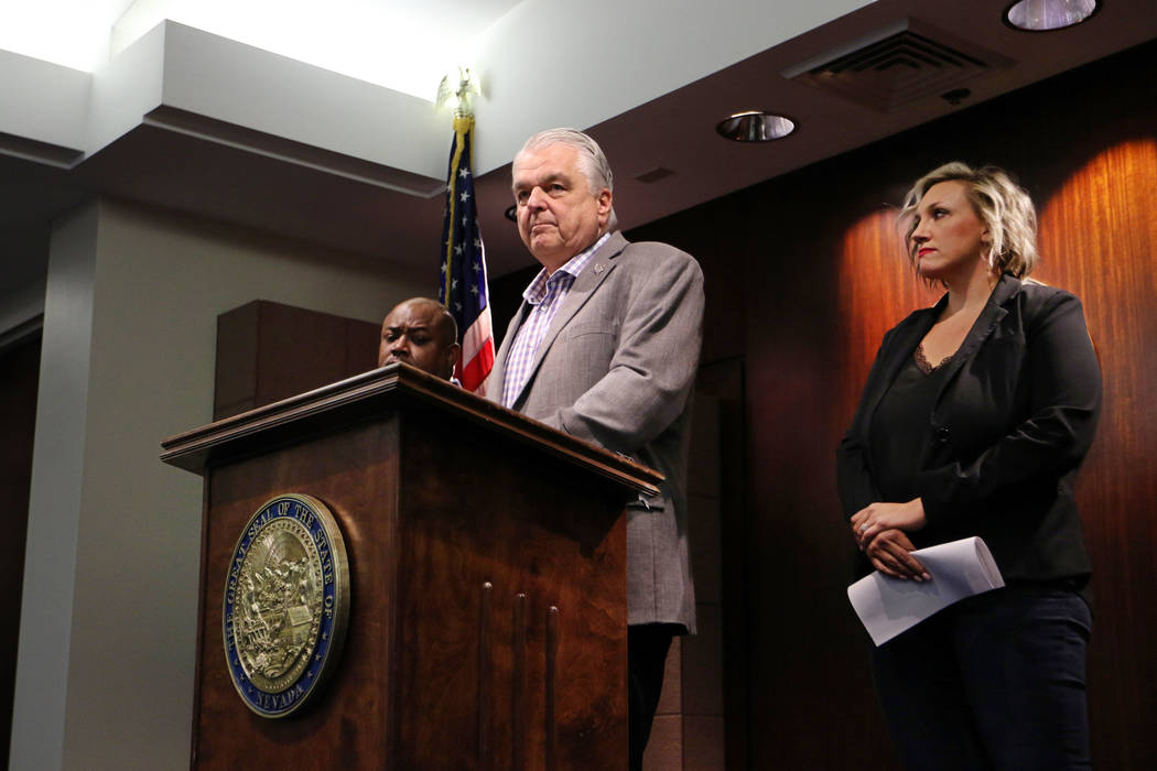 In this Aug. 23, 2019, file photo, Nevada Gov. Steve Sisolak, center, with Majority Leader Nico ...