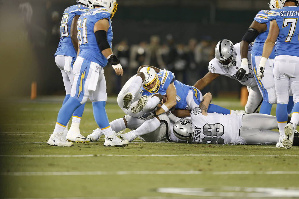 Los Angeles Chargers quarterback Philip Rivers, center, is sacked by Oakland Raiders defensive ...