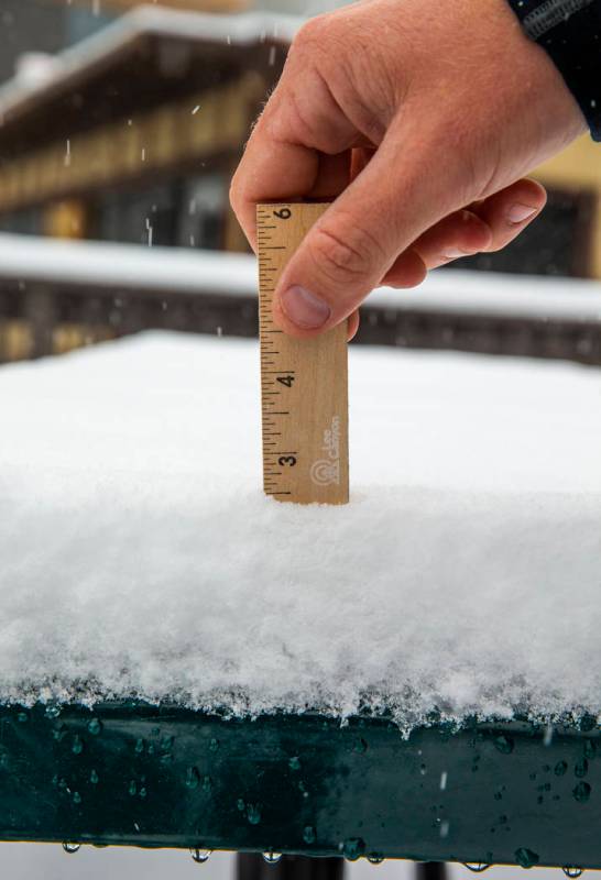 Media Specialist TJ Ropelato measures the recent snowfall currently at 2 1/2 inches about the L ...