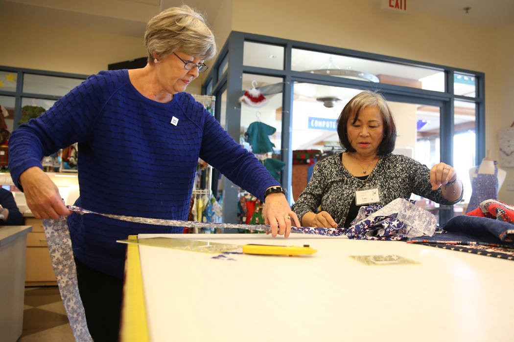 Group leader Bonnie Meadows, left, instructs Jane Arnold on working with a quilt during a meet ...
