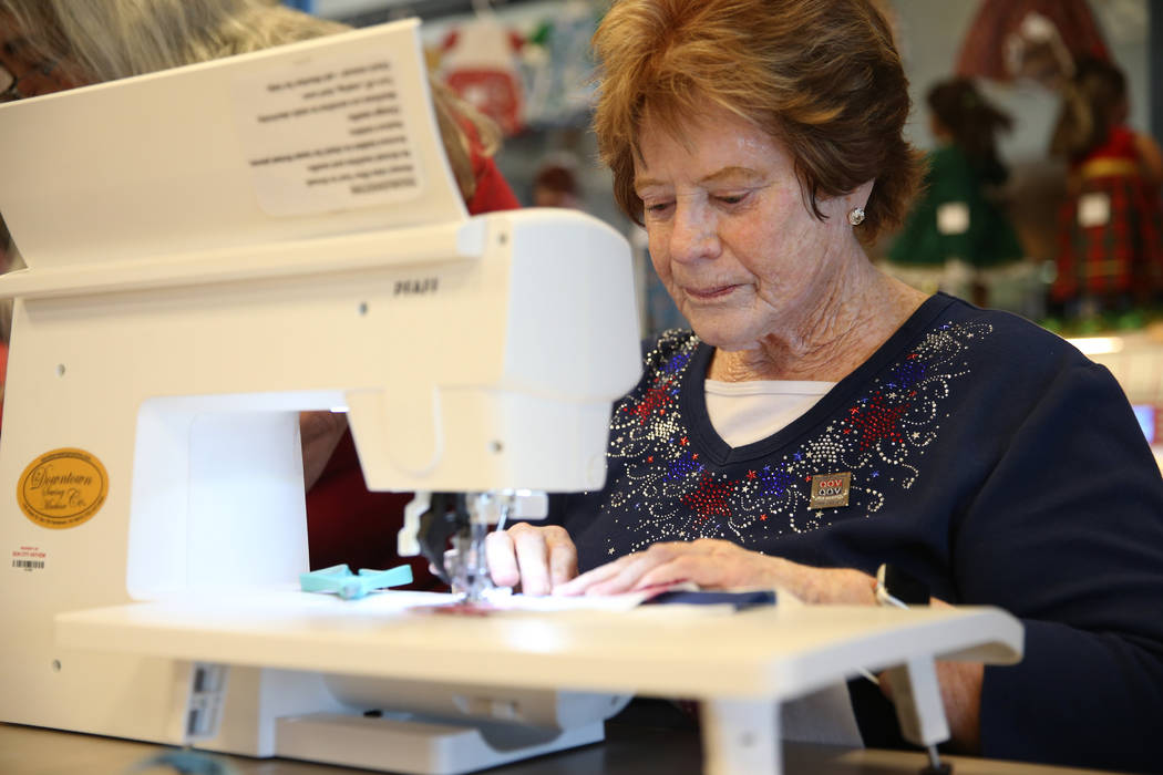 Brenda Graf stitches a pattern for a quilt during a meet by the Quilters for Veterans to make p ...