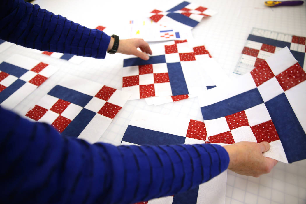 Group leader Bonnie Meadows shows the pattern of a quilt in the works during a meet by the Quil ...