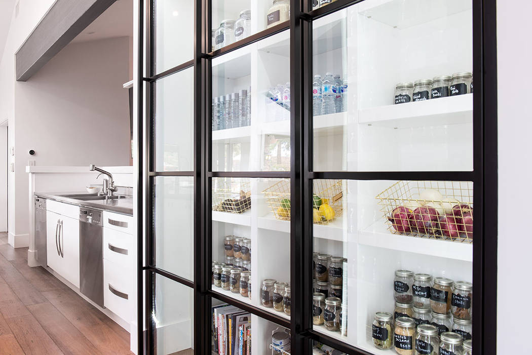 The kitchen showcases an expansive custom pantry with glass doors. (Simply Vegas)