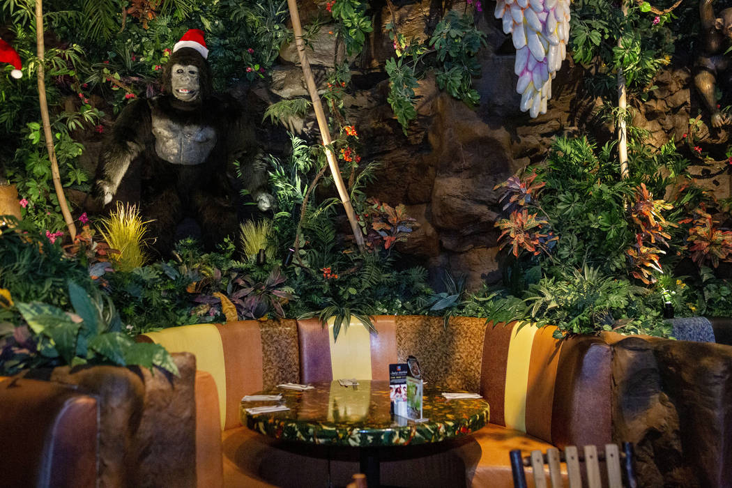 Dining tables covered by plants and mechanical animals in the Rainforest Cafe on the Las Vegas ...