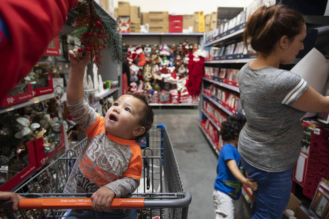 Alannah Tiumalu dangles mistletoe in front of Ele Brown, 2, as his brother, Salem Brown, 2, cli ...