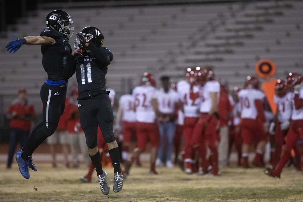 Desert Pines' Bren Coffman (26), left, and Jet Solomon (11), right, celebrate an interception b ...