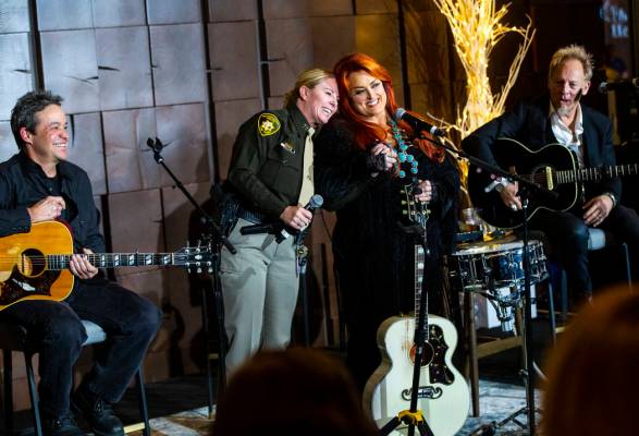 Metropolitan Police Department Capt. Kelly McMahill, second from left, embraces singer-songwrit ...