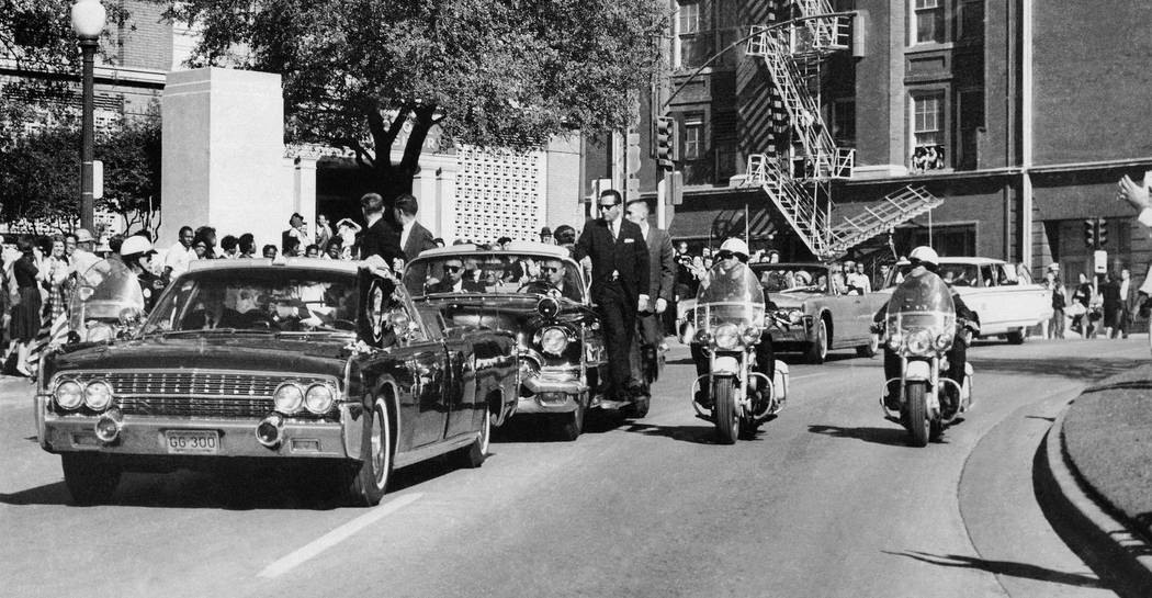 FILE - In this Nov. 22, 1963 file photo, seen through the foreground convertible's windshield, ...