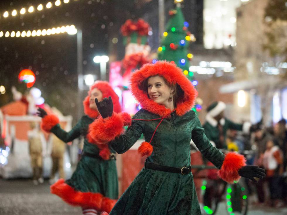 Performers wave to the crowd as the Downtown Summerlin Holiday Parade makes its way through Fes ...