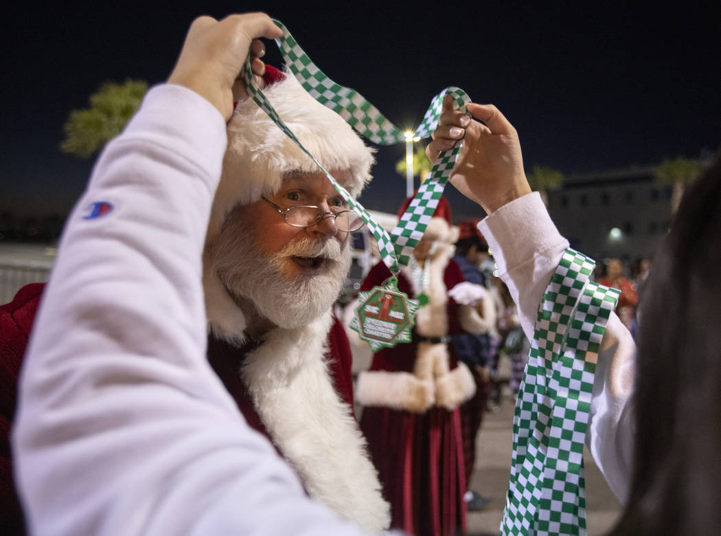 Joe Kauffman, dressed as Santa, accepts a medal for finishing the 1-Mile Walk at the seventh an ...