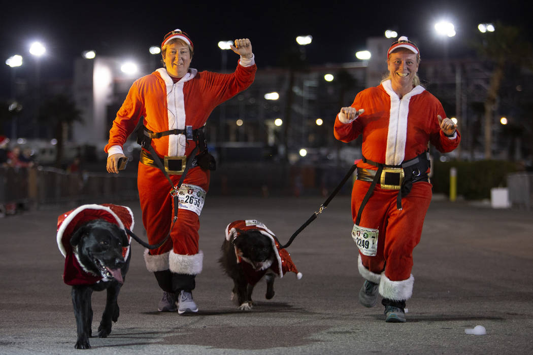 Rhys Miller and Tai, left, and Erika Balderson and Tere, right, finish the PJ 5K & 1-Mile W ...