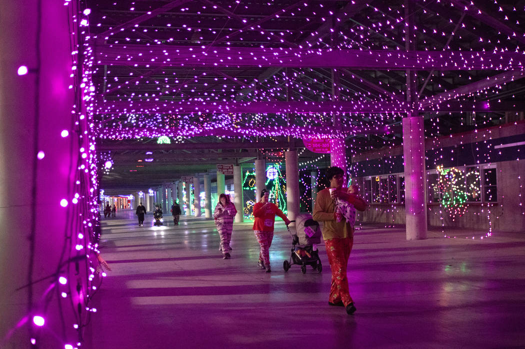 Participants in the seventh annual PJ 5K & 1-Mile Walk move through Glittering Lights on Su ...