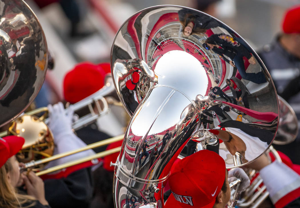 Fans and band members are reflected in a tuba as the UNLV band performs during the fourth quart ...