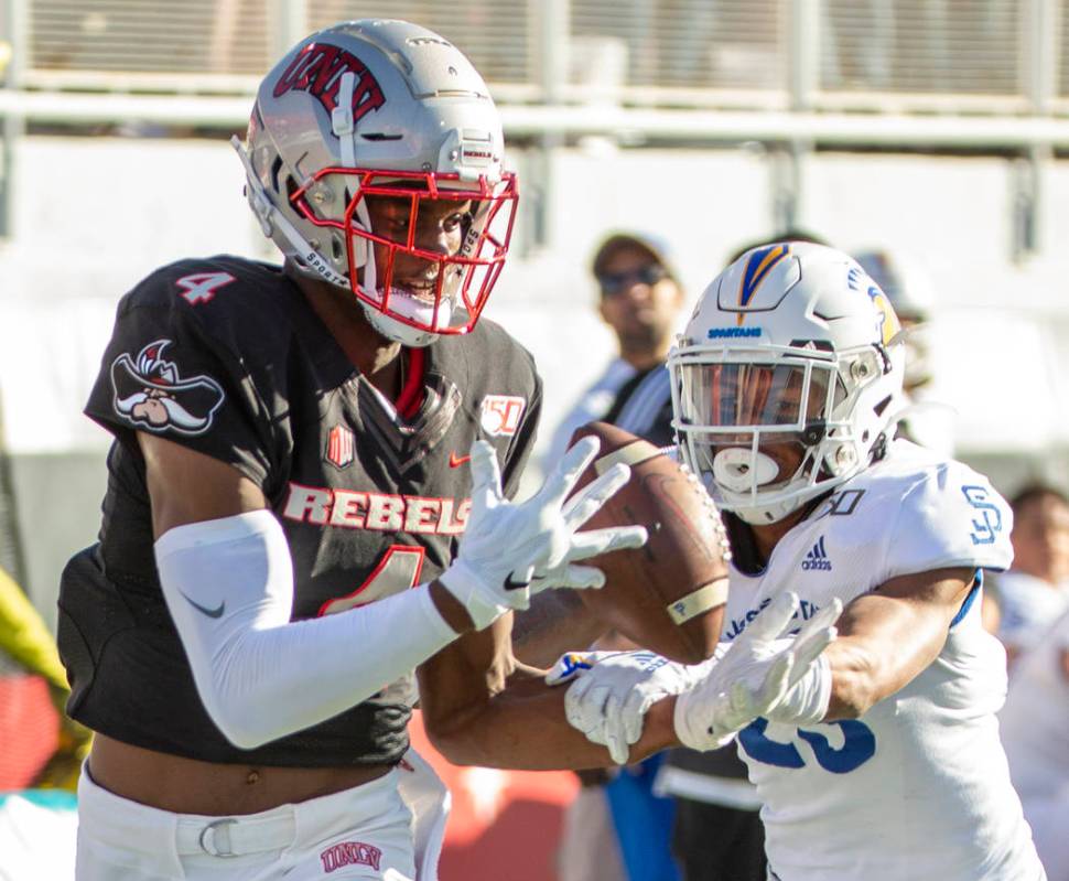 UNLV Rebels wide receiver Randal Grimes (4, left) eyes a long pass for a touchdown over the San ...