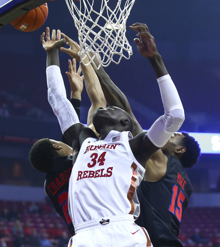 UNLV's Cheikh Mbacke Diong (34) battles for a rebound against Southern Methodist's Ethan Chargo ...