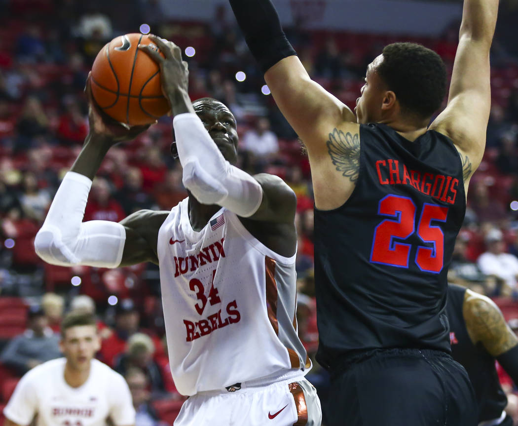 UNLV's Cheikh Mbacke Diong (34) looks to shoot past Southern Methodist's Ethan Chargois (25) du ...