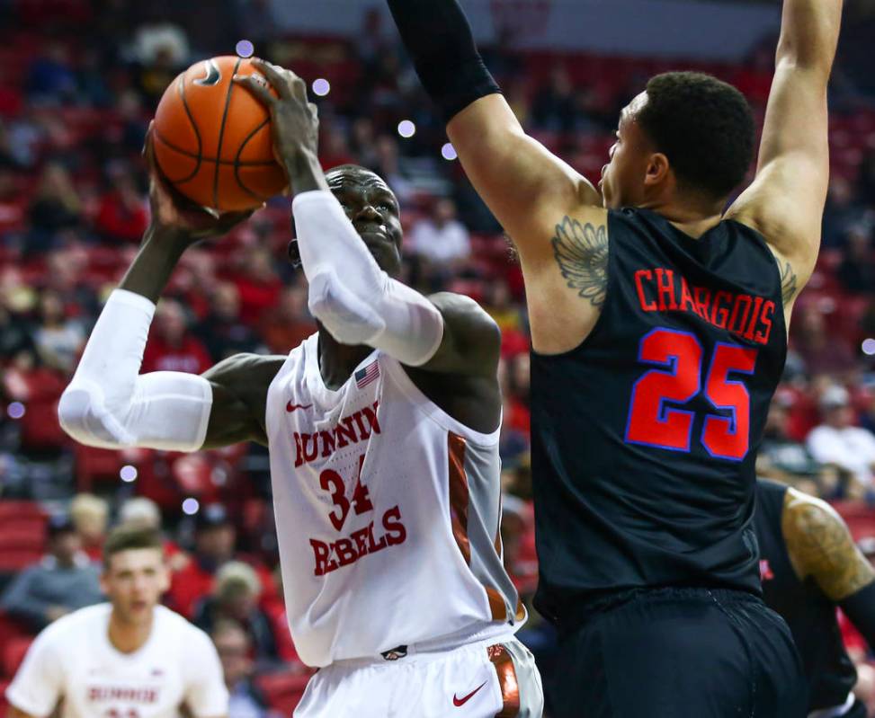 UNLV's Cheikh Mbacke Diong (34) looks to shoot past Southern Methodist's Ethan Chargois (25) du ...