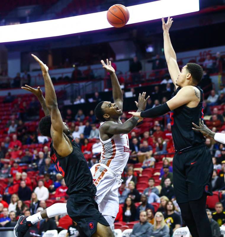 UNLV's Amauri Hardy (3) loses possession of the ball between Southern Methodist's Isiaha Mike, ...