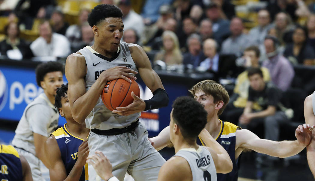 Colorado guard Tyler Bey pulls in a rebound in front of UC Irvine forwards Austin Johnson, back ...