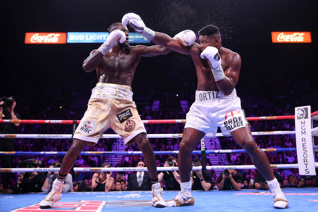 Deontay Wilder, left, battles Luis Ortiz during the sixth round of the WBC heavyweight title bo ...