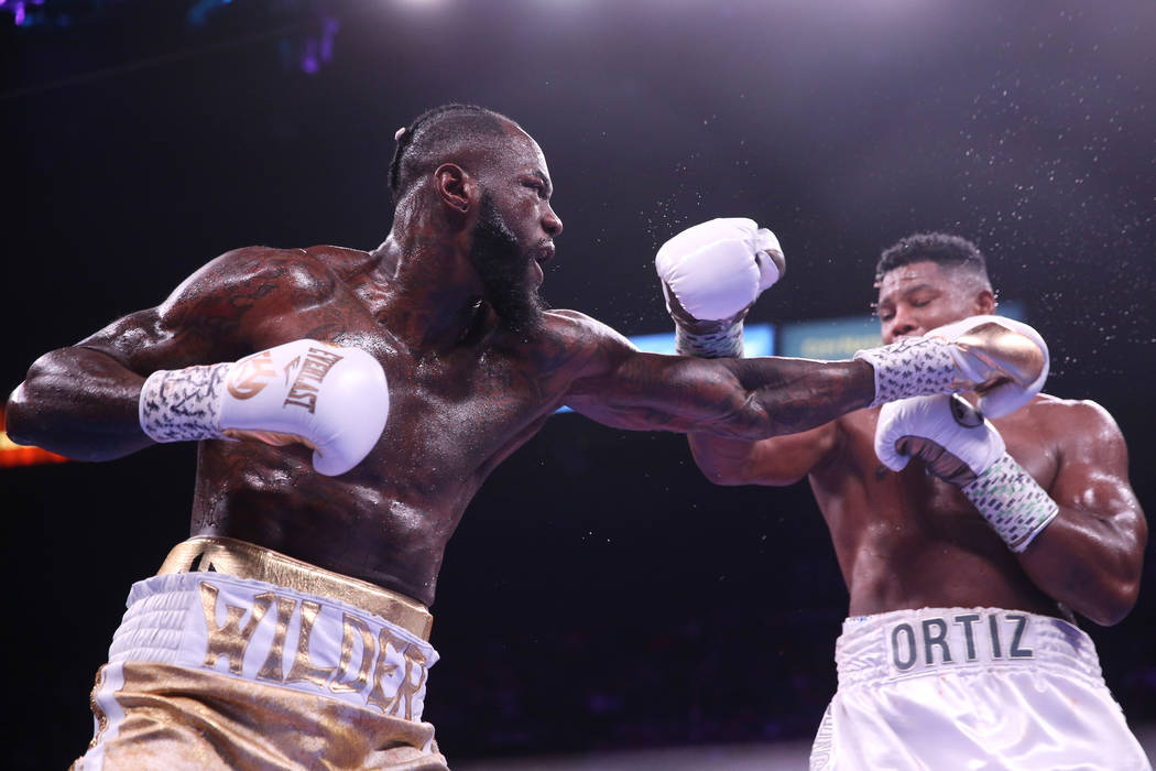 Deontay Wilder, left, battles Luis Ortiz during the sixth round of the WBC heavyweight title bo ...