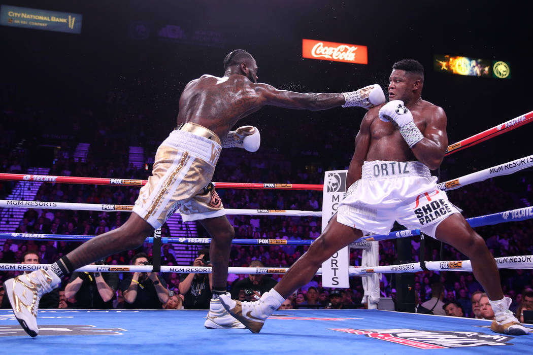 Deontay Wilder, left, throws a punch against Luis Ortiz during the fifth round of the WBC heavy ...