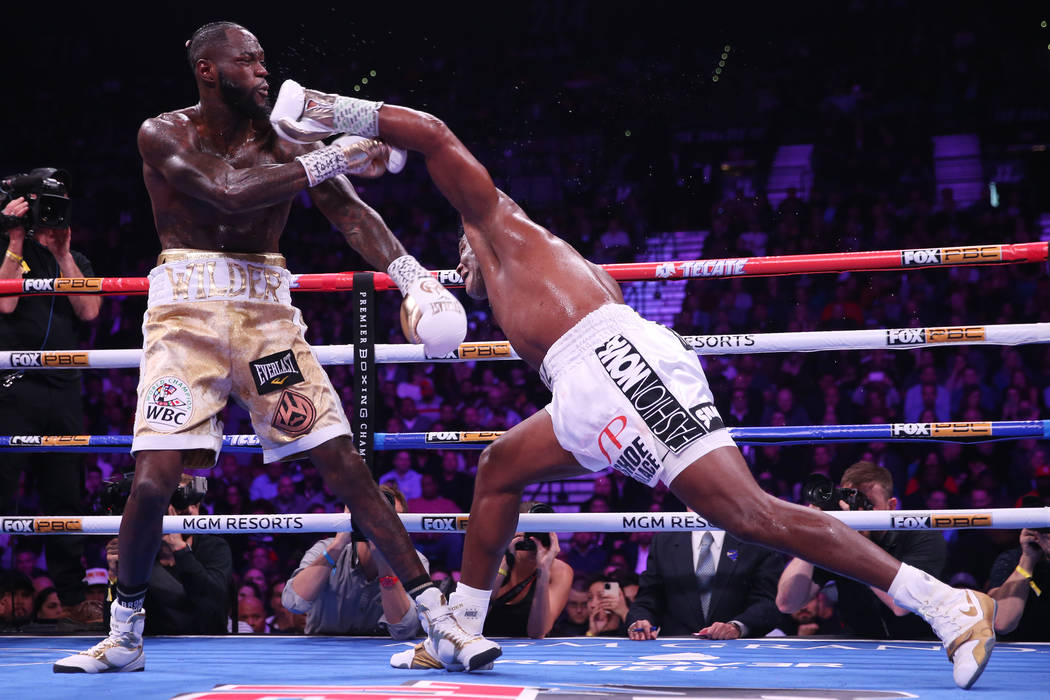 Luis Ortiz, right, throw a punch against Deontay Wilder during the fifth round of the WBC heavy ...