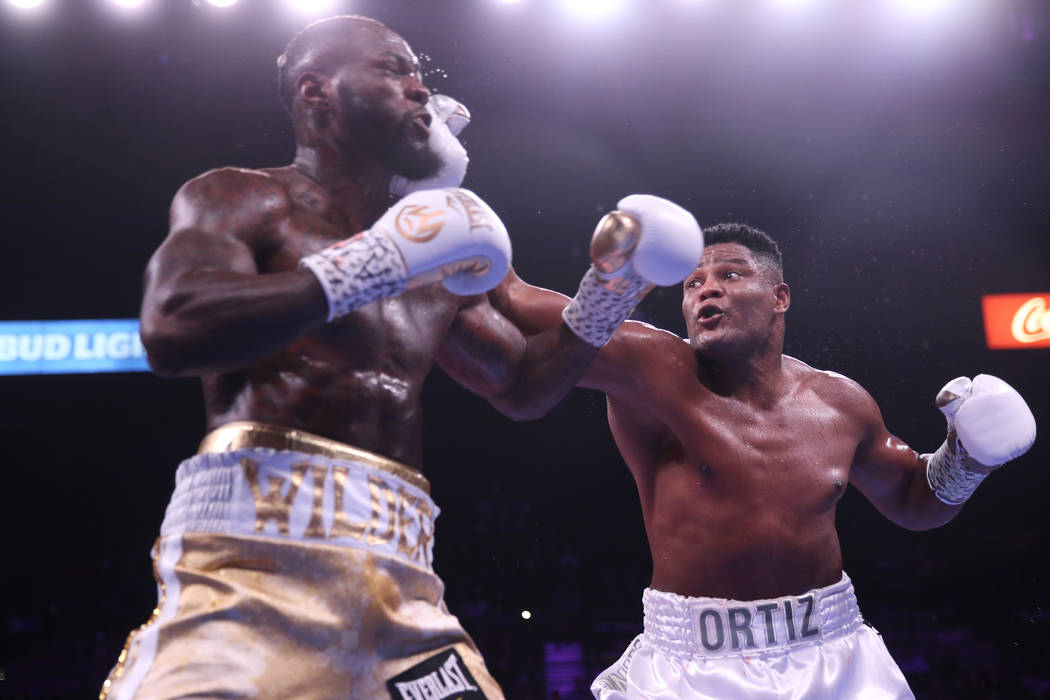Luis Ortiz, right, lands a punch against Deontay Wilder during the third round of the WBC heavy ...