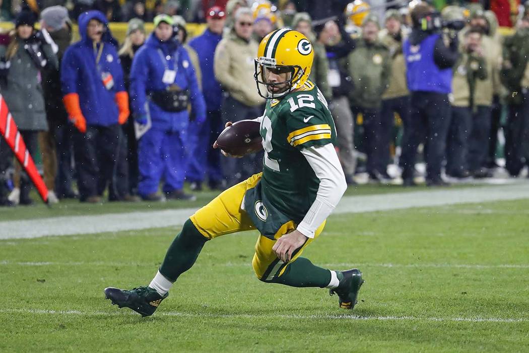 Green Bay Packers quarterback Aaron Rodgers slides while running the ball during an NFL footbal ...