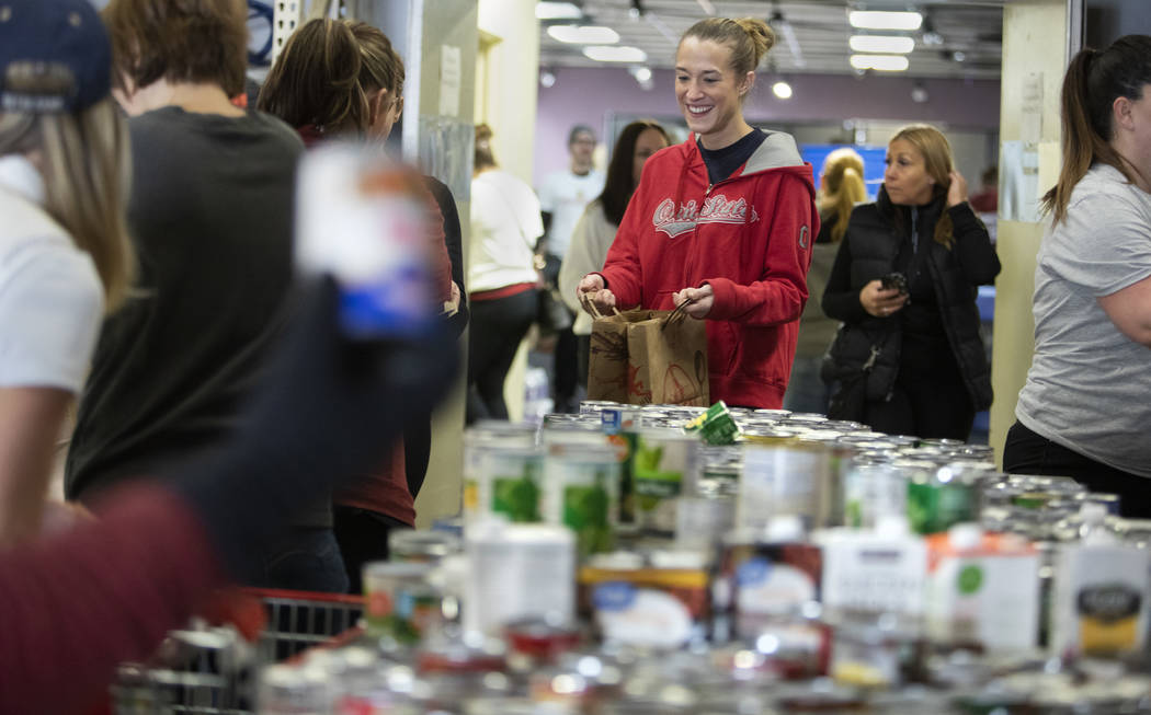 Abbi Jankowski, a member of Junior League of Las Vegas, fills up a bag with food at the "D ...