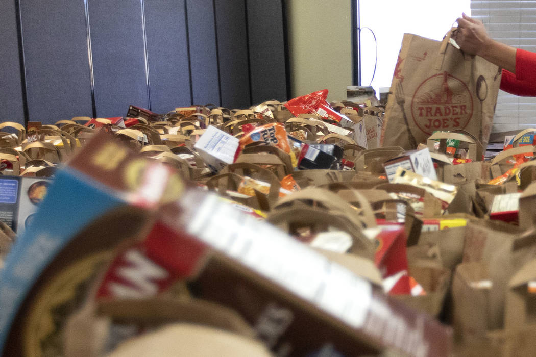 Attendees of the "Done in a Day" event fill approximately 2,500 bags of donated food ...