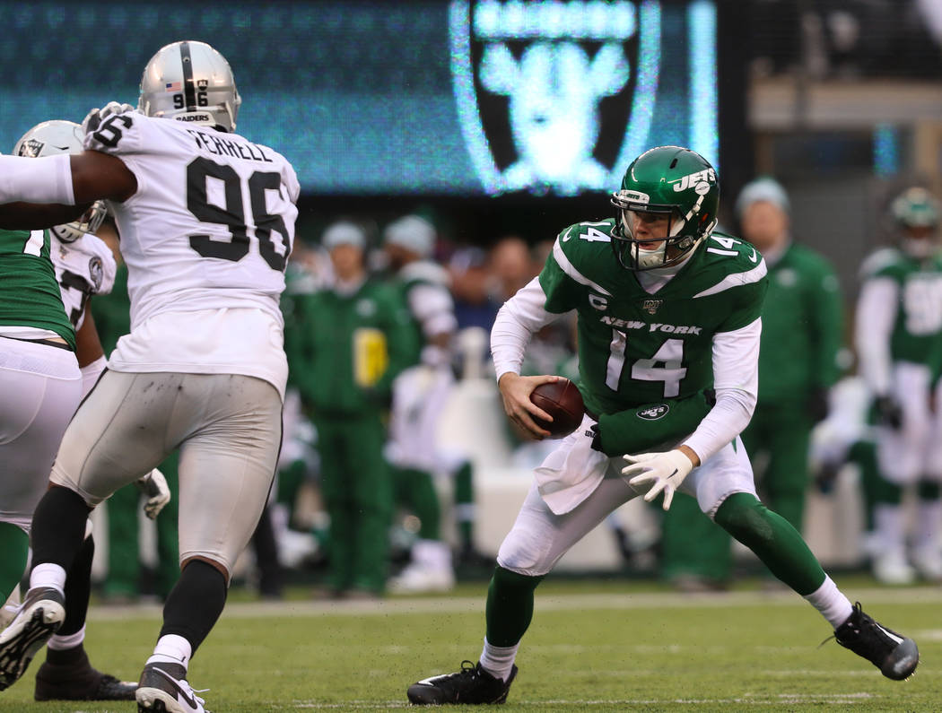 New York Jets quarterback Sam Darnold (14) scrambles with the football as Oakland Raiders defen ...