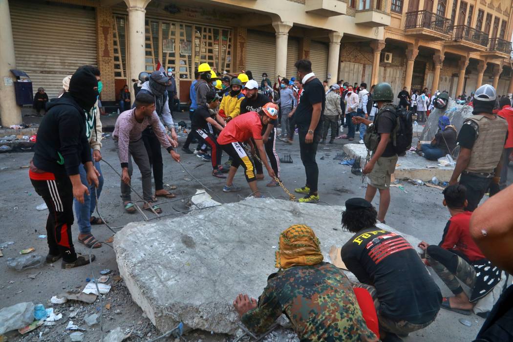 Demonstrators remove concrete walls placed by Iraqi security forces to close in the historic Ra ...