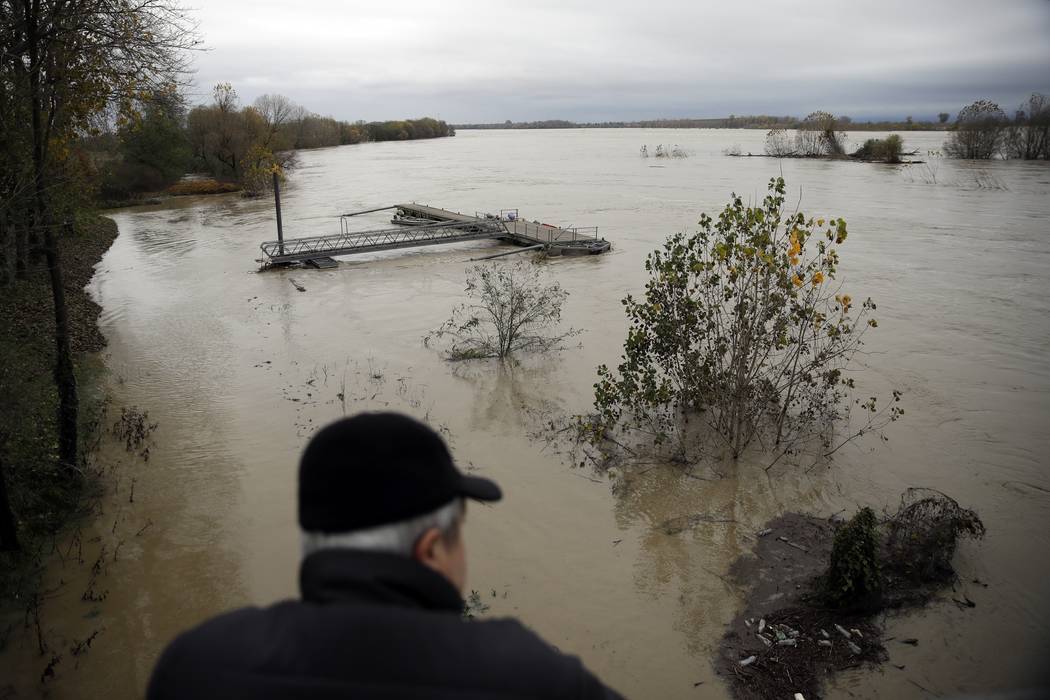 A man watches a swollen Po river in Mezzana Bigli, near Pavia, northern Italy, Sunday, Nov. 24, ...