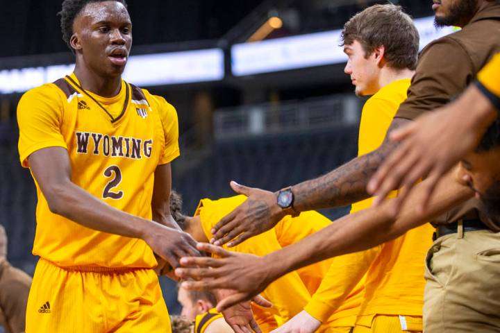 Wyoming guard A.J. Banks (2) gets some encouragement from teammates on the bench versus Colorad ...