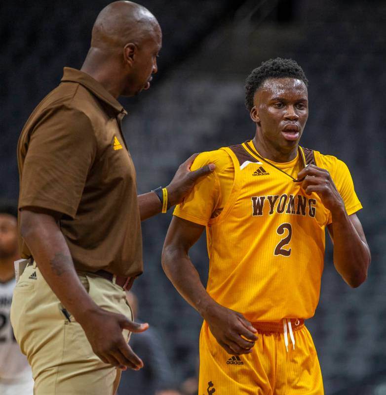 Wyoming head coach Tad Boyle, left, counsels guard A.J. Banks (2) while battling Wyoming during ...