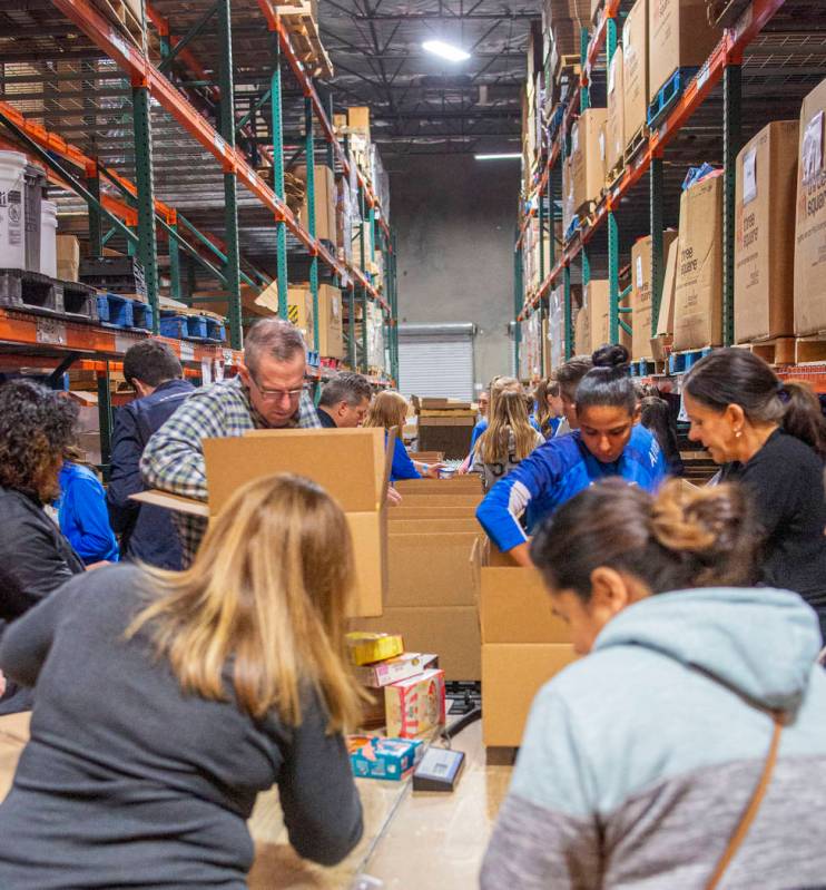 The Las Vegas Albion Soccer Club pack assorted foods in preparation for Thanksgiving at Three S ...