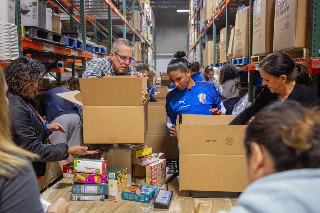 The Las Vegas Albion Soccer Club pack assorted foods in preparation for Thanksgiving at Three S ...