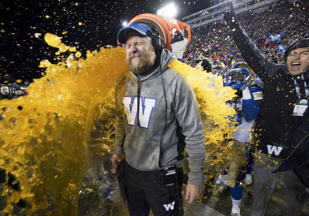 Winnipeg Blue Bombers head coach Mike O'Shea gets a sports drink poured over him as his team de ...