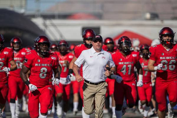 UNLV Rebels head coach Tony Sanchez leads his team on to the field before the start of their NC ...