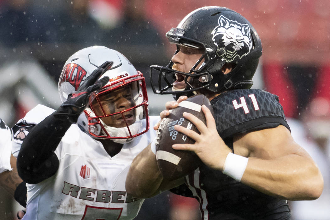 Arkansas State punter Cody Grace (41) handles the ball as UNLV defensive back Jericho Flowers ( ...