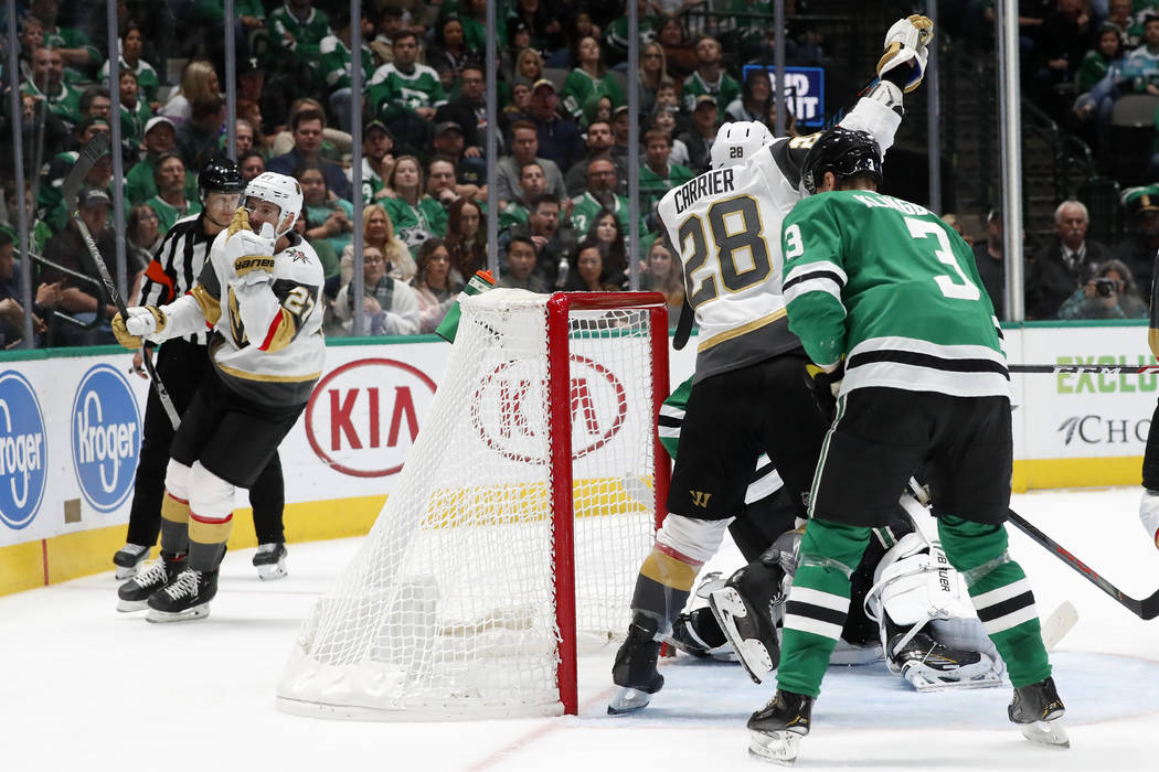 Vegas Golden Knights defenseman Shea Theodore, left, skates behind the net after scoring in an ...